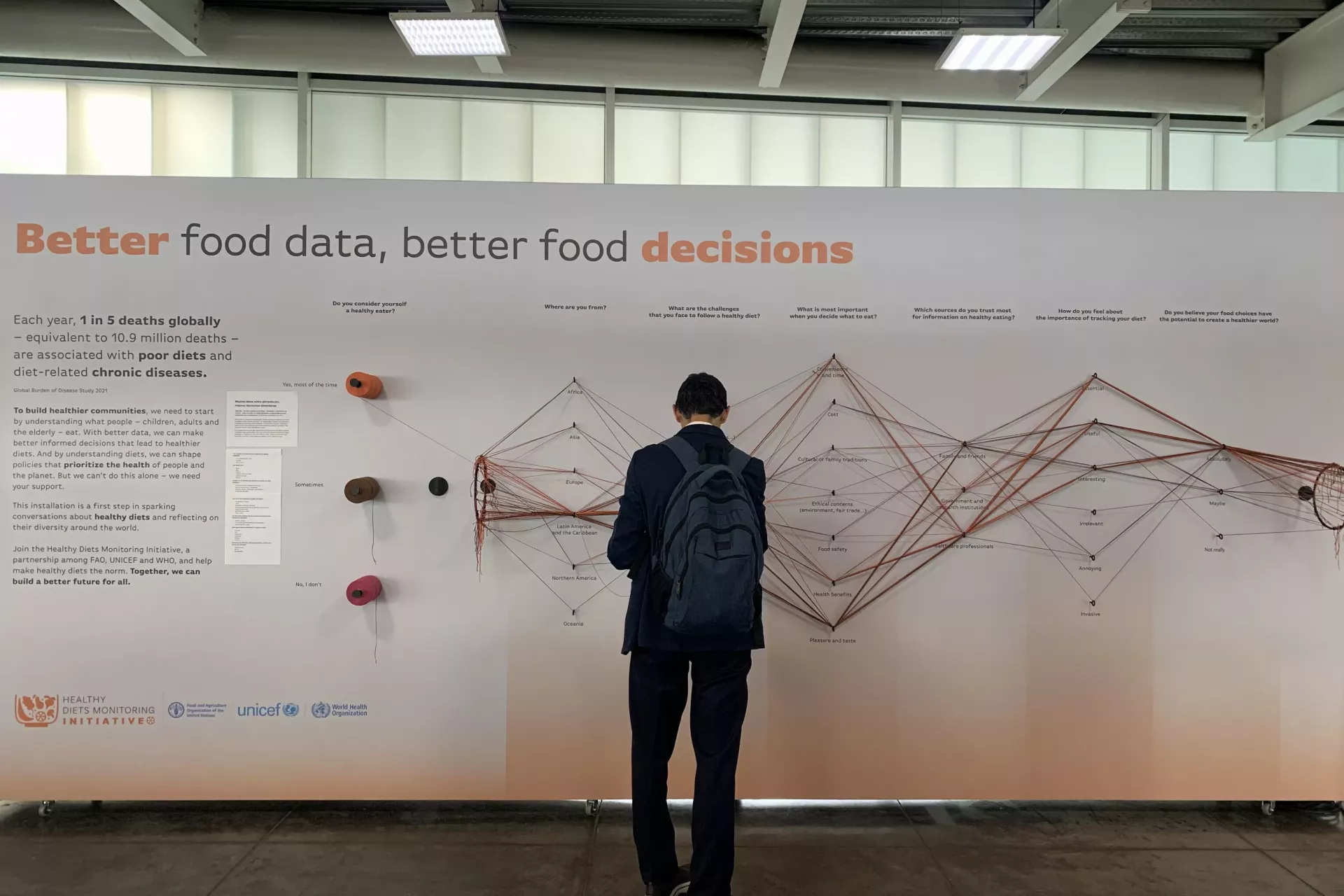 A standing man participating to the data visualization installation Data Strings